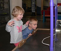 Kids playing in a muzeum with rubber-cord powered cars