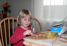 Lisa decorating Christmas gingerbread house