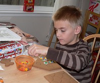 Tom decorating Christmas gingerbread house