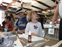 Kids making balsa airplanes — Tom focused and self-reliant, Lisa with parental help.