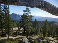 Half Dome vykukuje skrz oblouk.